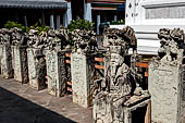 Bangkok Wat Arun - Detail of the precint of the sacred area of the ubosot with chinese noble man sitting on chair. 